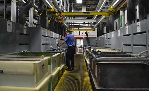 Person working on electroless nickel plating assembly line